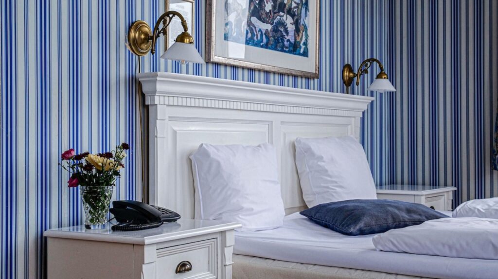 double bed with blue striped wallpaper